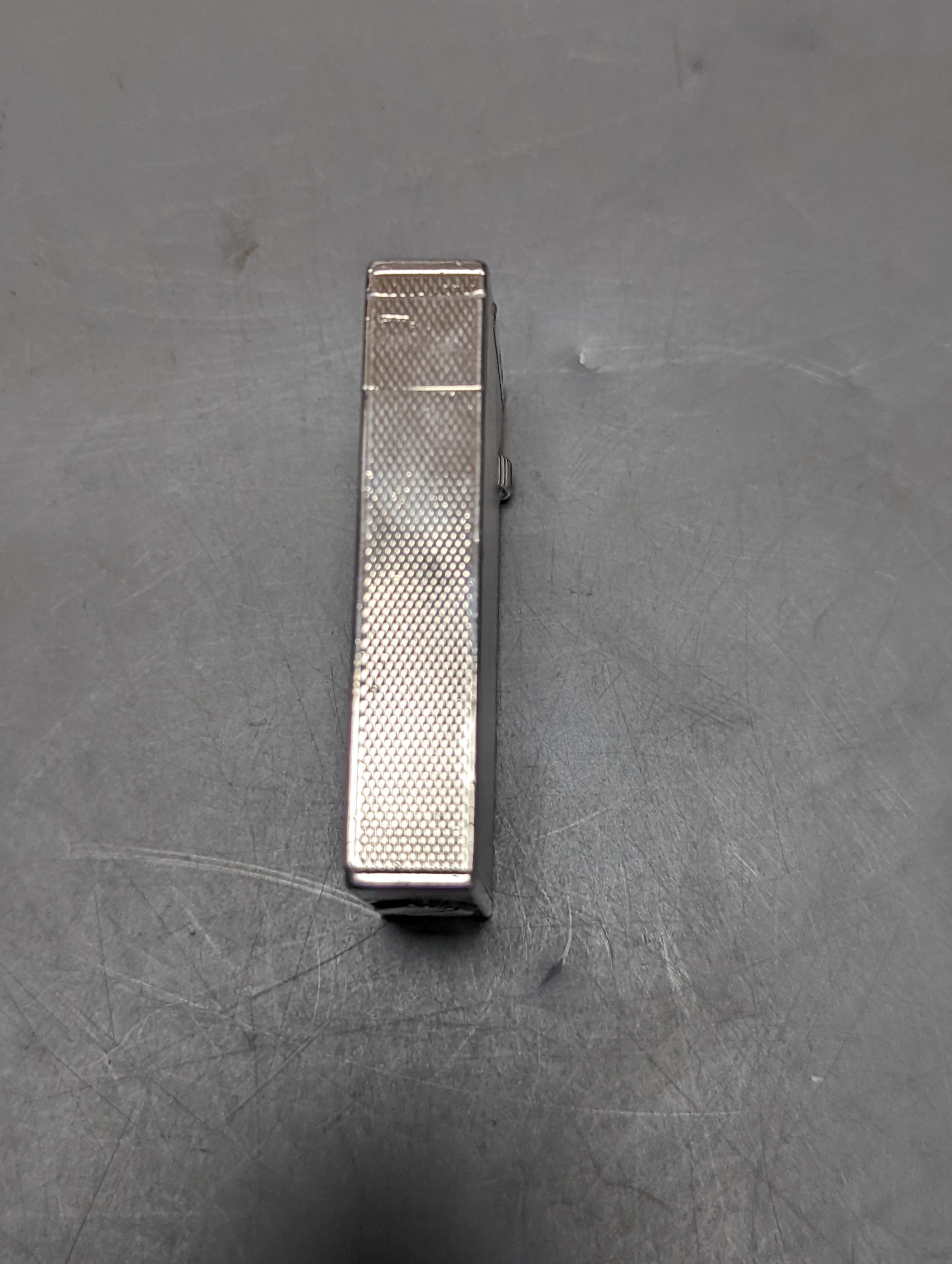 A George VI engine turned silver mounted Dunhill lighter, London, 1945, 57mm.